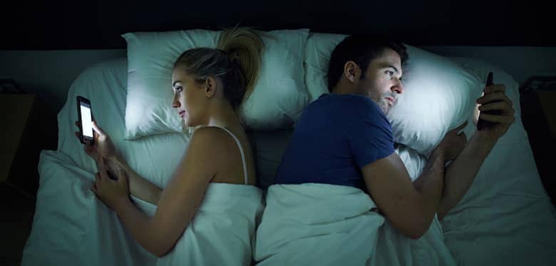 Couple In Bed On Mobile Phones